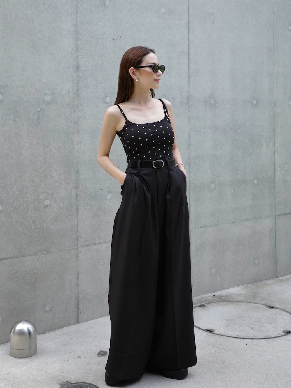 ブラック系のパンツ、ブラック系のキャミソール、ブラック系のサンダルを着用したレディースの夏コーディネートの3枚目の写真