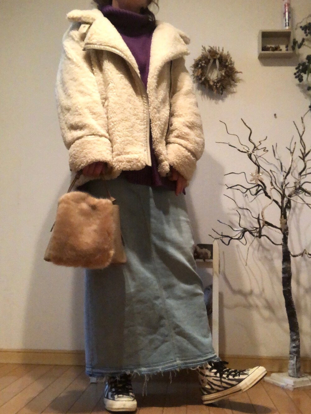 ブラック系のスニーカー、ブルー系のデニムスカート、ブラウン系のショルダーバッグを着用したレディースの冬コーディネートの2枚目の写真