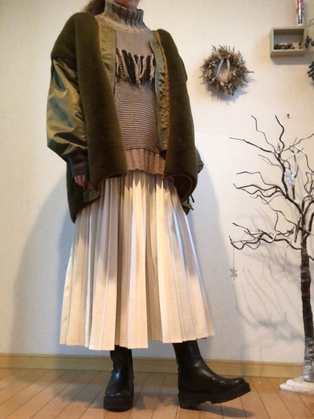 ブラウン系のニット/セーター、ベージュ系のトートバッグ、ブラック系のブーツを着用したレディースの冬コーディネートの2枚目の写真