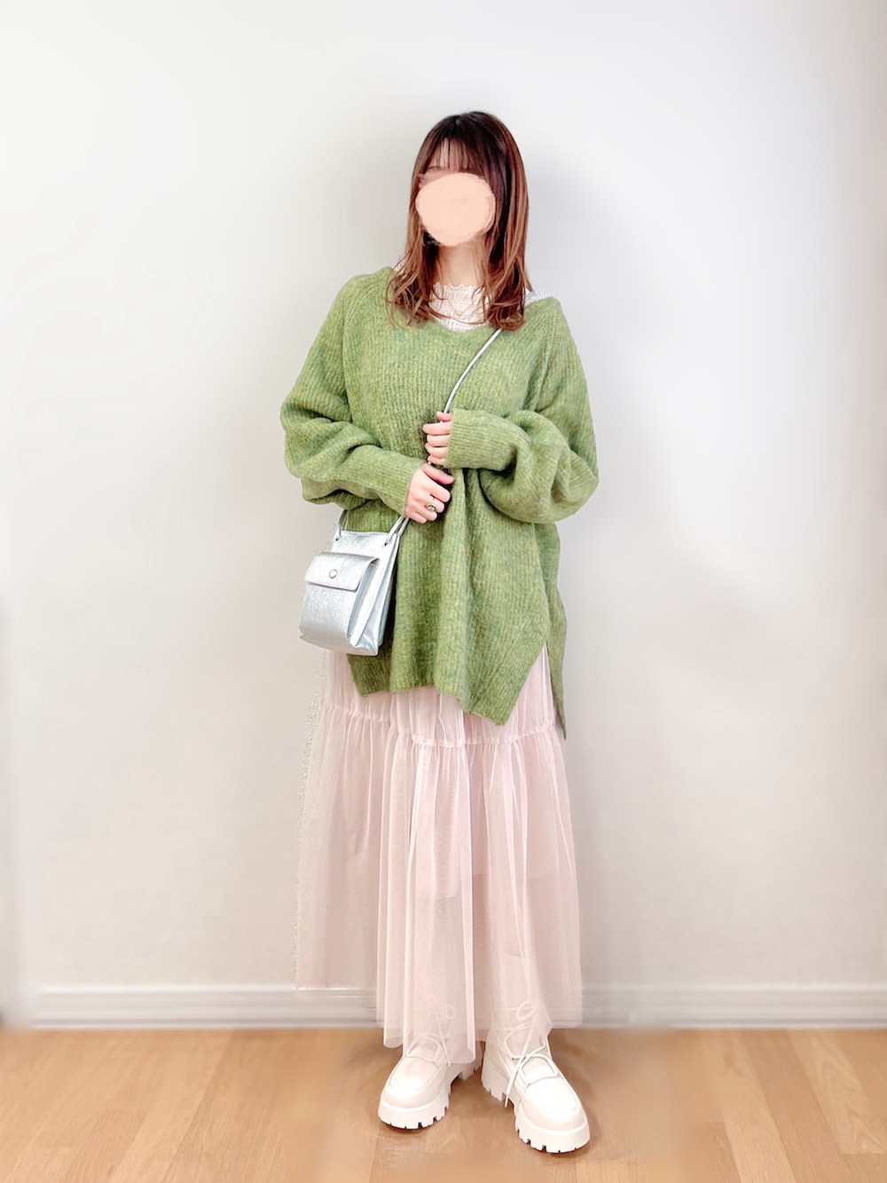 グリーン系のニット/セーター、ホワイト系のTシャツ/カットソー、ベージュ系のワンピースを着用したレディースの冬コーディネートの2枚目の写真