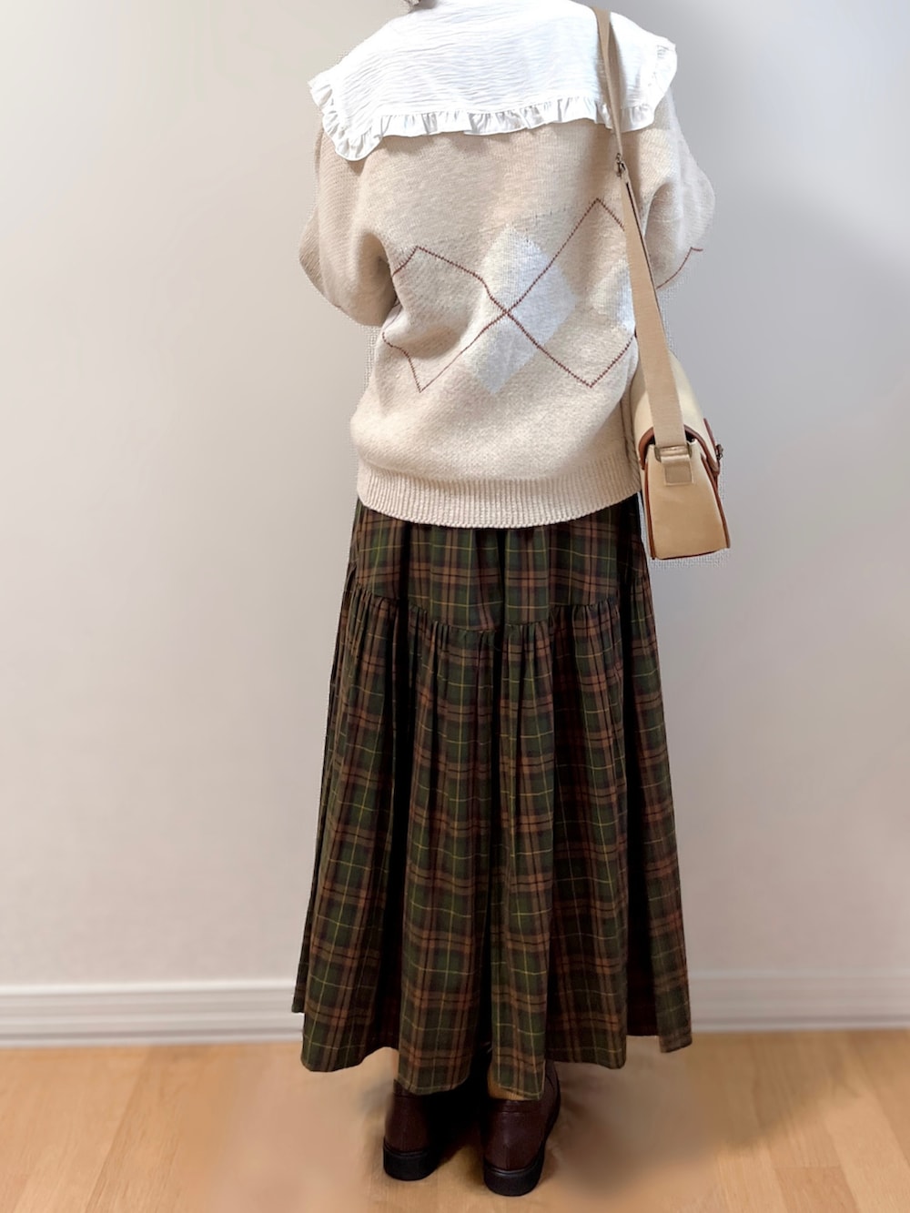 ベージュ系のカーディガン/ボレロ、ホワイト系のシャツ/ブラウス、ブラウン系のスカートを着用したレディースの秋コーディネートの5枚目の写真