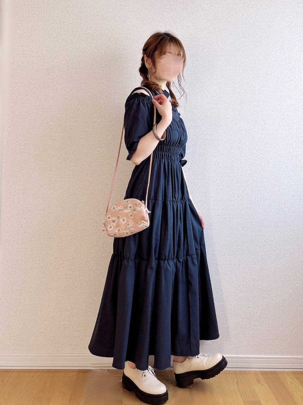 ブルー系のワンピース、ベージュ系のボストンバッグ、ベージュ系のパンプスを着用したレディースの夏コーディネートの2枚目の写真