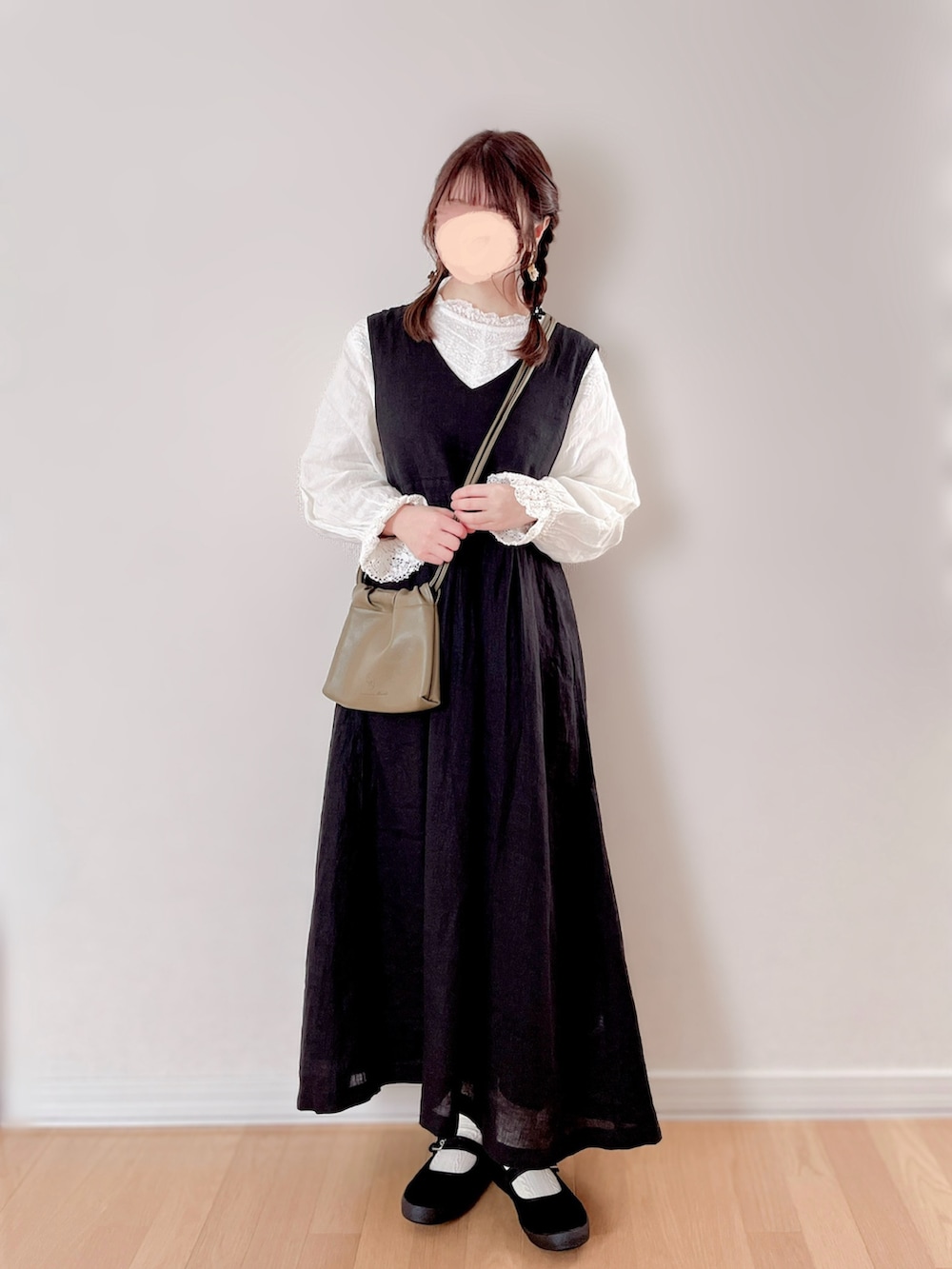 ブラック系のワンピース/ドレス、ホワイト系のバッグ、ブラック系のスニーカーを着用したレディースの冬コーディネートの2枚目の写真