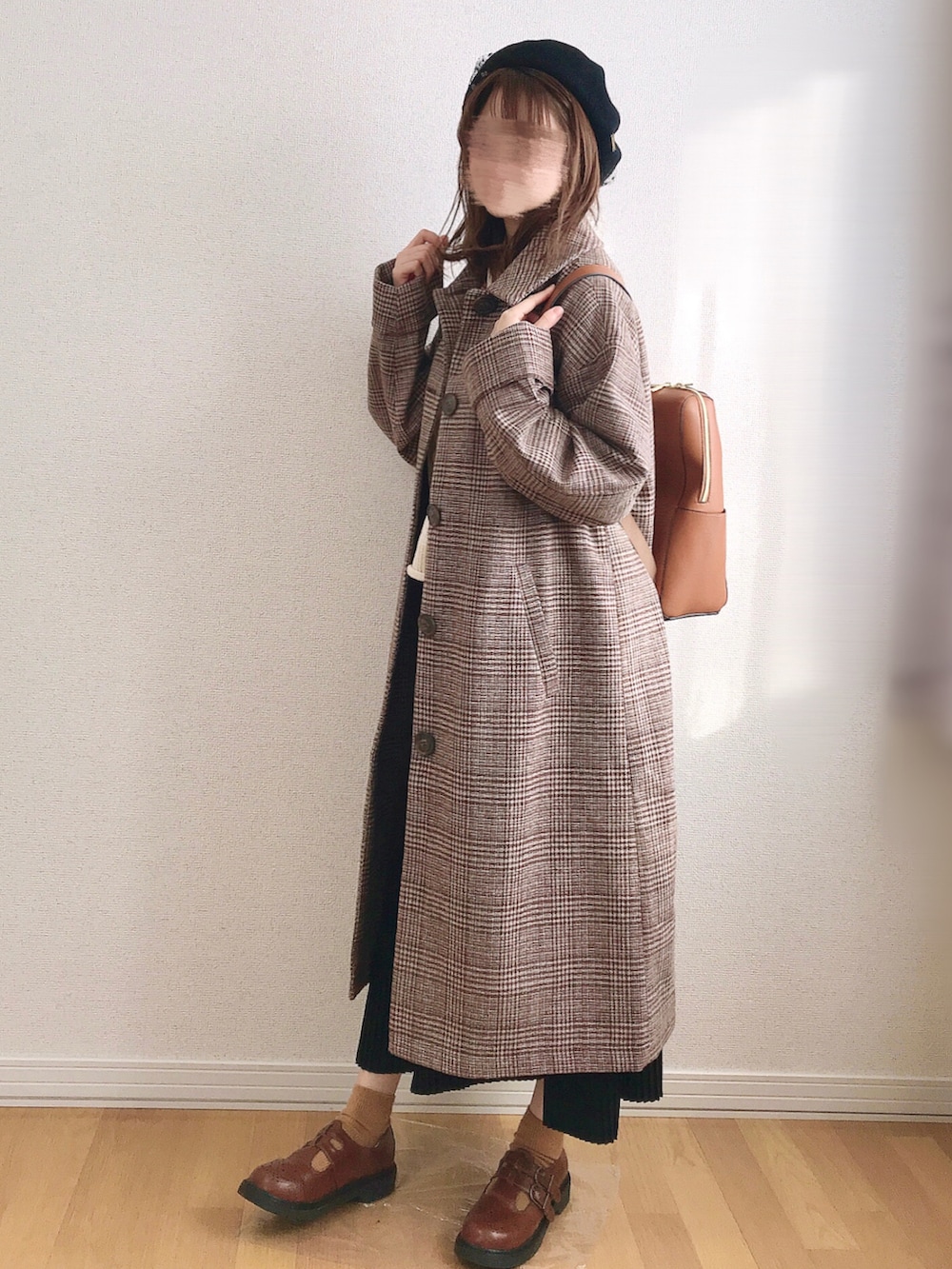 ブラウン系のステンカラーコート、ベージュ系のベスト、イエロー系のドレスシューズを着用したレディースの冬コーディネートの2枚目の写真