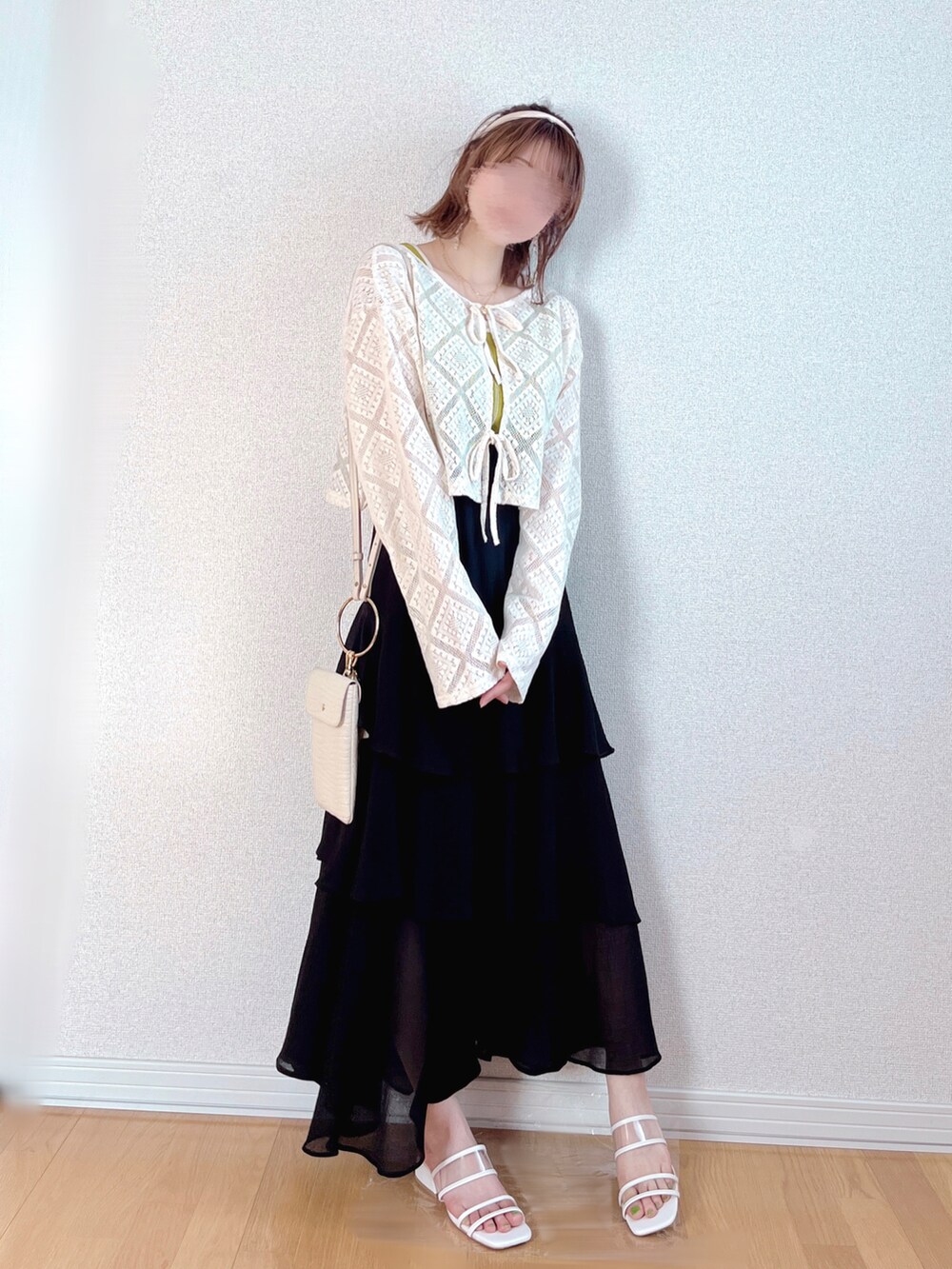 ブラック系のスカート、ホワイト系のカーディガン/ボレロ、ホワイト系のショルダーバッグを着用したレディースの秋コーディネートの2枚目の写真