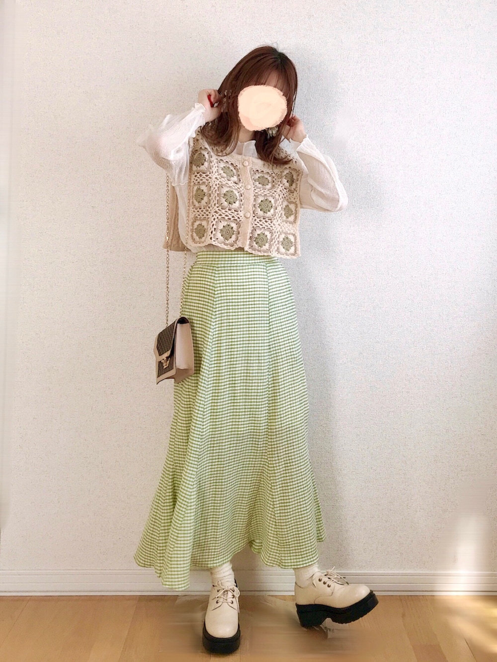 グリーン系のスカート、ホワイト系のベスト、ホワイト系のTシャツ/カットソーを着用したレディースの春コーディネートの3枚目の写真