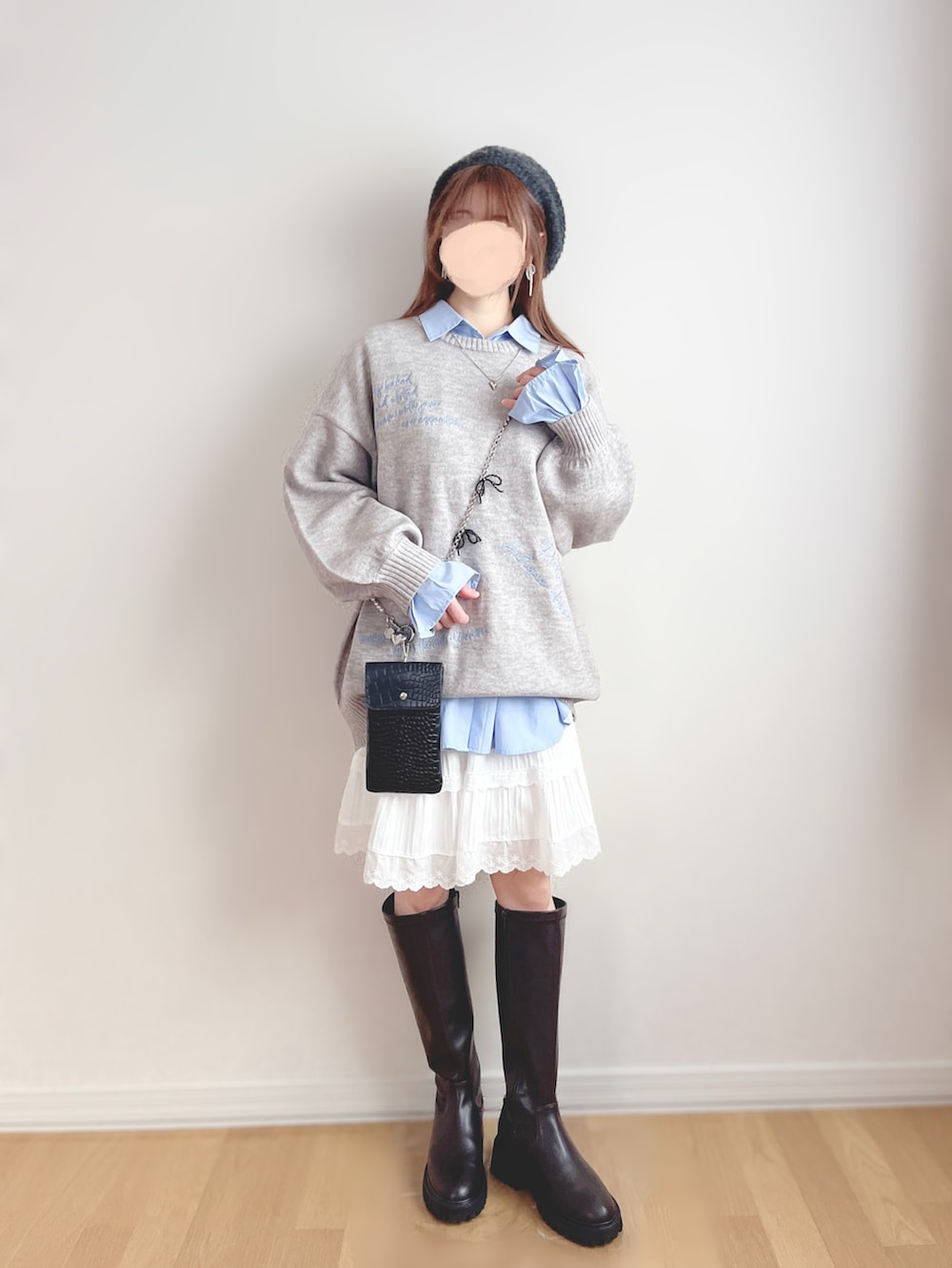 グレー系のニット/セーター、ブルー系のシャツ/ブラウス、ホワイト系のスカートを着用したレディースの春コーディネートの3枚目の写真