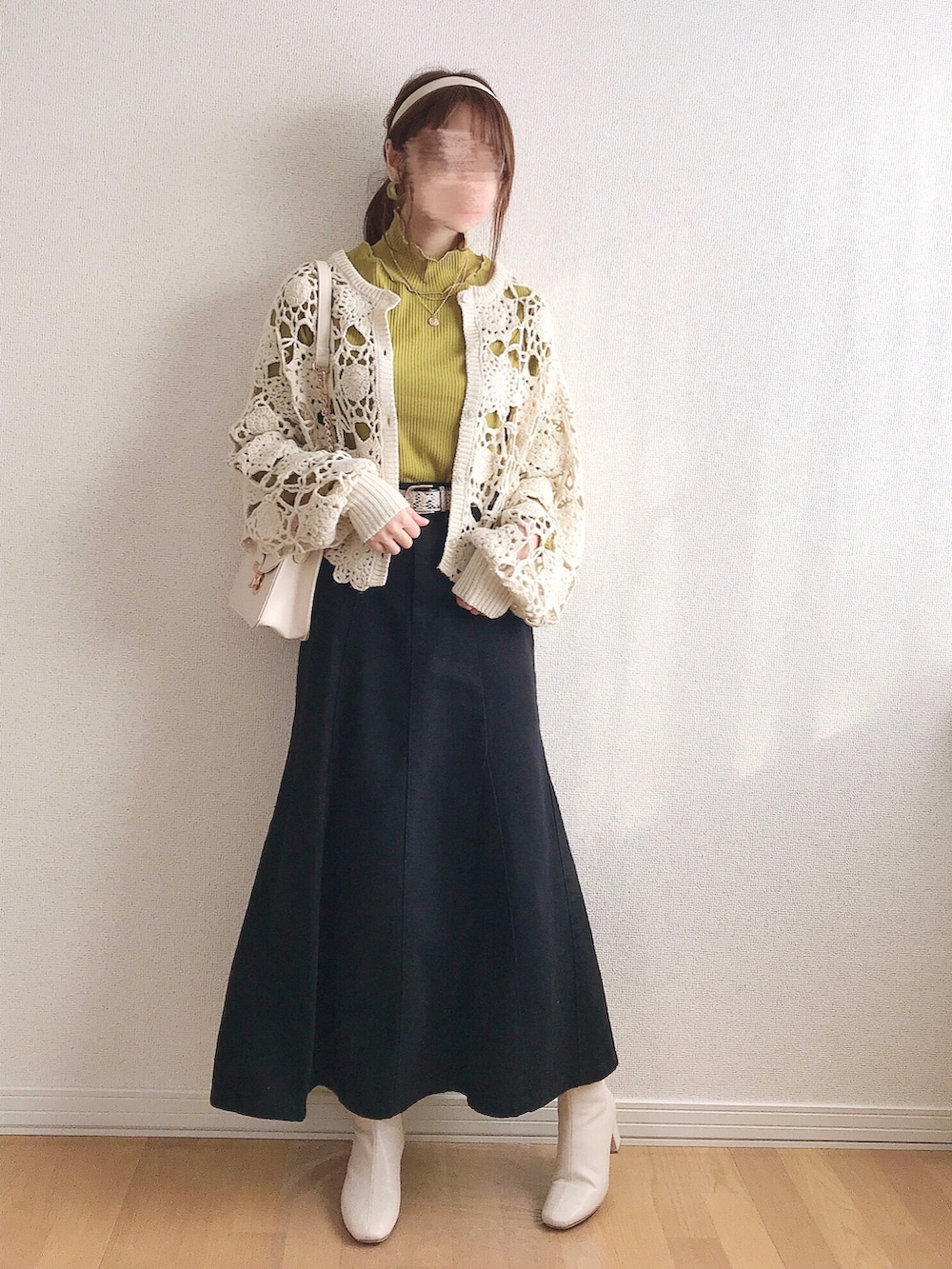 ホワイト系のカーディガン/ボレロ、イエロー系のTシャツ/カットソー、ブラック系のデニムスカートを着用したレディースの冬コーディネートの4枚目の写真