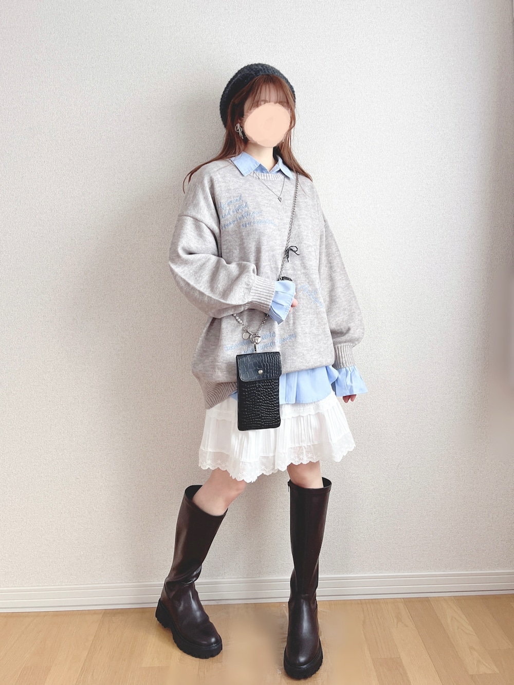 グレー系のニット/セーター、ブルー系のシャツ/ブラウス、ホワイト系のスカートを着用したレディースの春コーディネートの2枚目の写真
