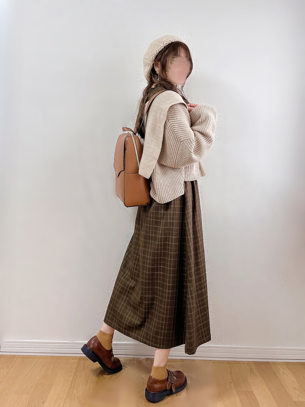 グリーン系のワンピース、ベージュ系のカーディガン/ボレロ、イエロー系のバックパック/リュックを着用したレディースの冬コーディネートの3枚目の写真