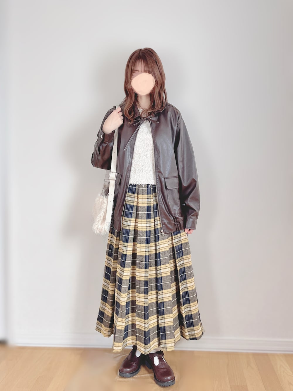 ブラウン系のブルゾン、ホワイト系のベスト、ホワイト系のTシャツ/カットソーを着用したレディースの冬コーディネートの3枚目の写真