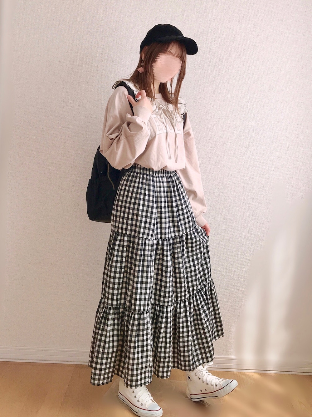 ピンク系のスウェット、ベージュ系のスカート、ホワイト系のスニーカーを着用したレディースの春コーディネートの3枚目の写真