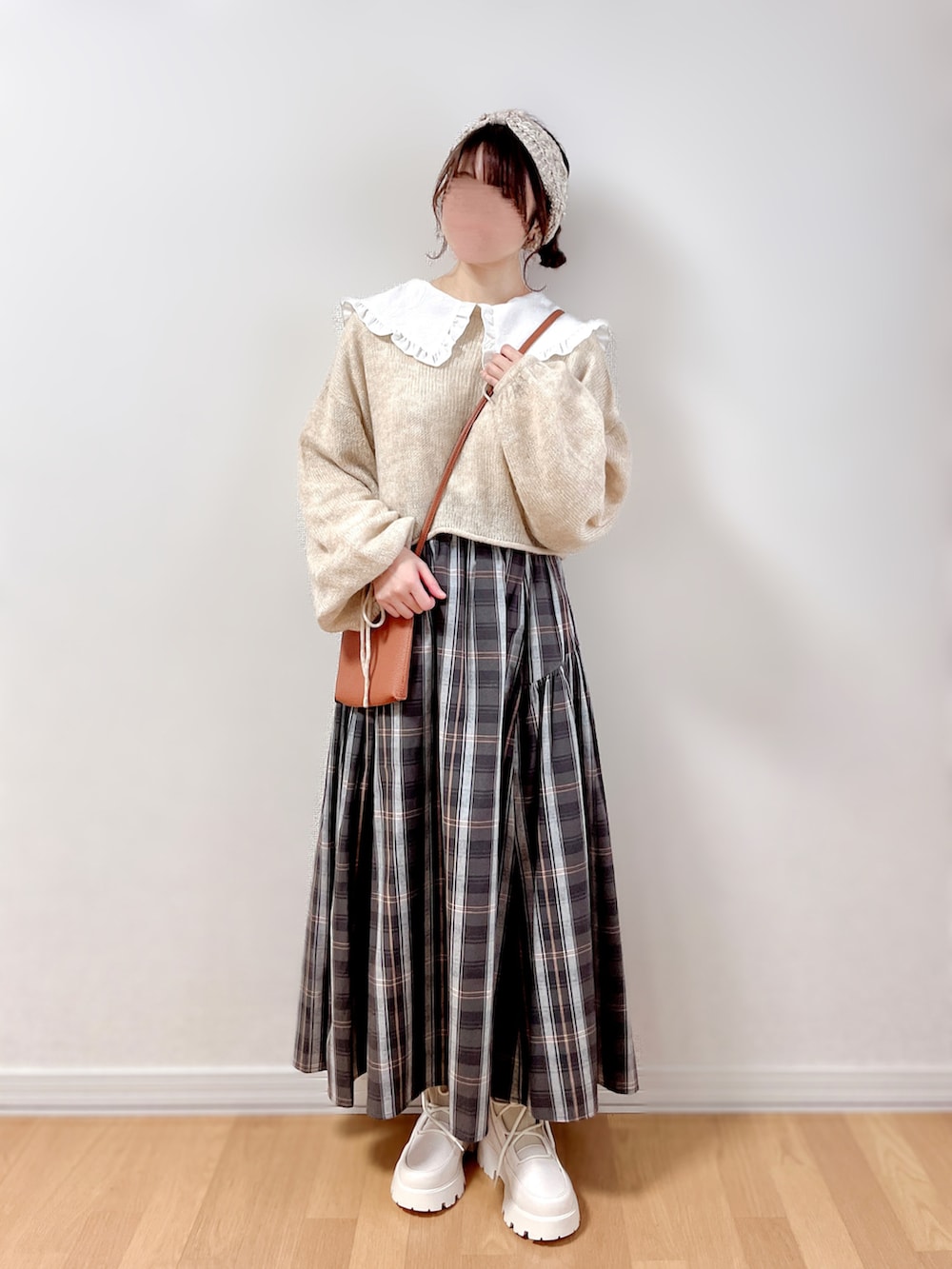 ベージュ系のニット/セーター、ホワイト系のシャツ/ブラウス、ブラウン系のバッグを着用したレディースの冬コーディネートの2枚目の写真
