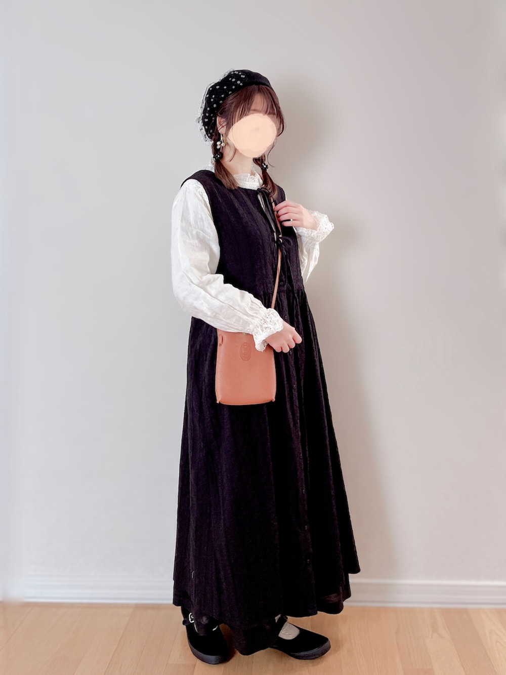 ブラック系のワンピース/ドレス、ホワイト系のバッグ、ブラック系のスニーカーを着用したレディースの冬コーディネートの3枚目の写真