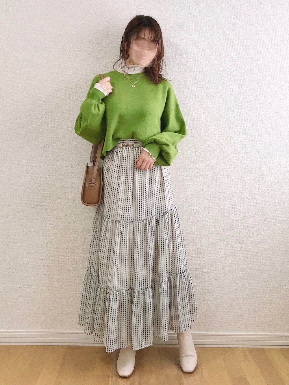 グリーン系のニット/セーター、ホワイト系のTシャツ/カットソー、ホワイト系のスカートを着用したレディースの冬コーディネートの2枚目の写真