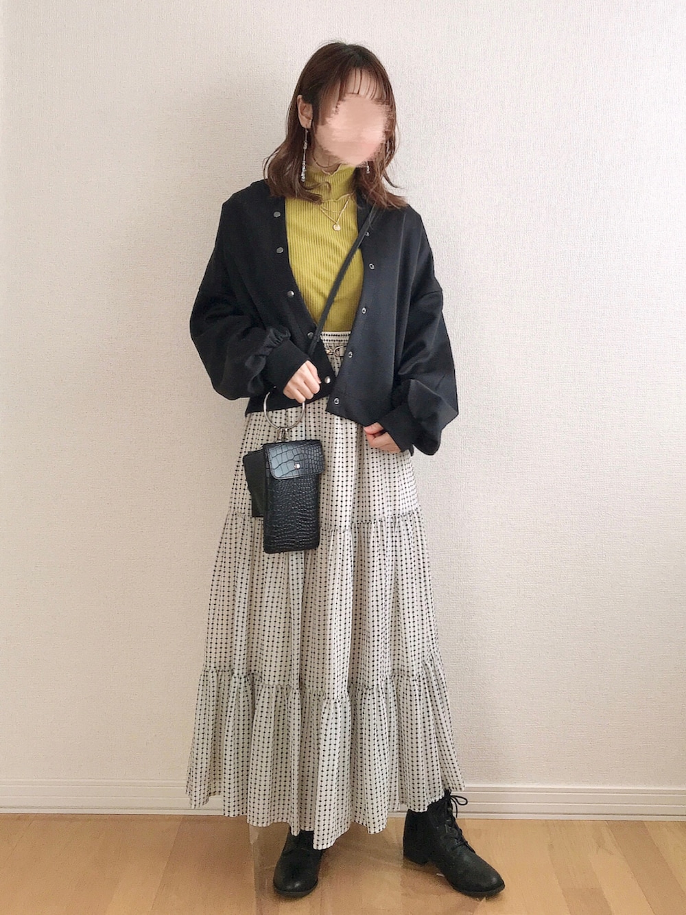 イエロー系のTシャツ/カットソー、ホワイト系のスカート、ブラック系のブーツを着用したレディースの春コーディネートの3枚目の写真