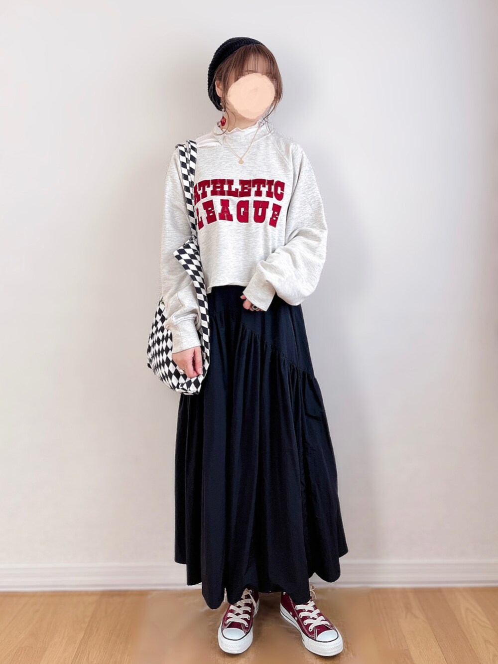 グレー系のスウェット、ホワイト系のTシャツ/カットソー、ブラック系のスカートを着用したレディースの春コーディネートの2枚目の写真