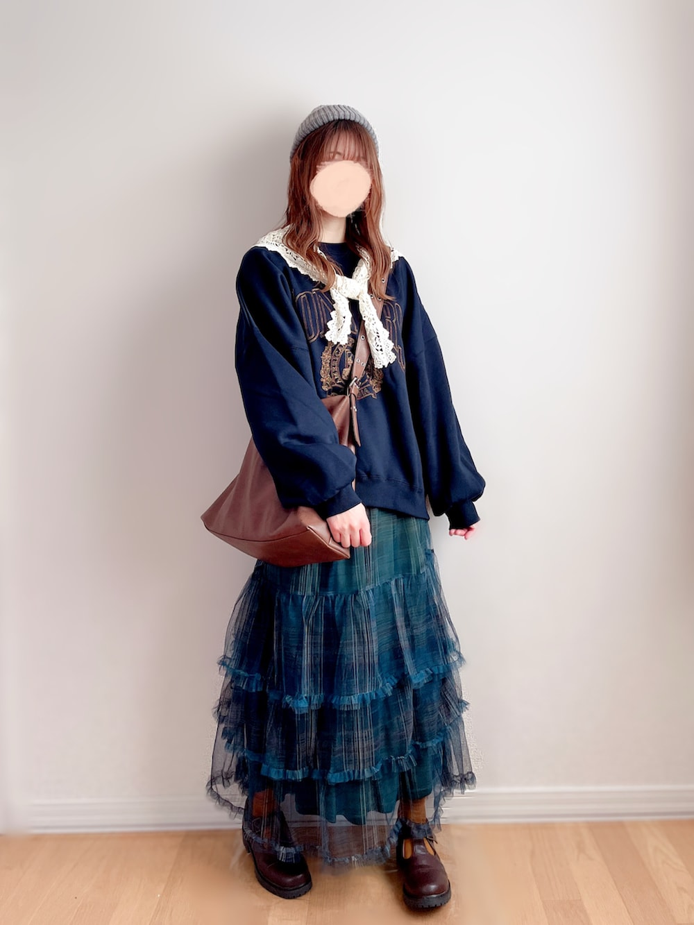 ブルー系のスウェット、グリーン系のスカート、ブラウン系のショルダーバッグを着用したレディースの冬コーディネートの3枚目の写真