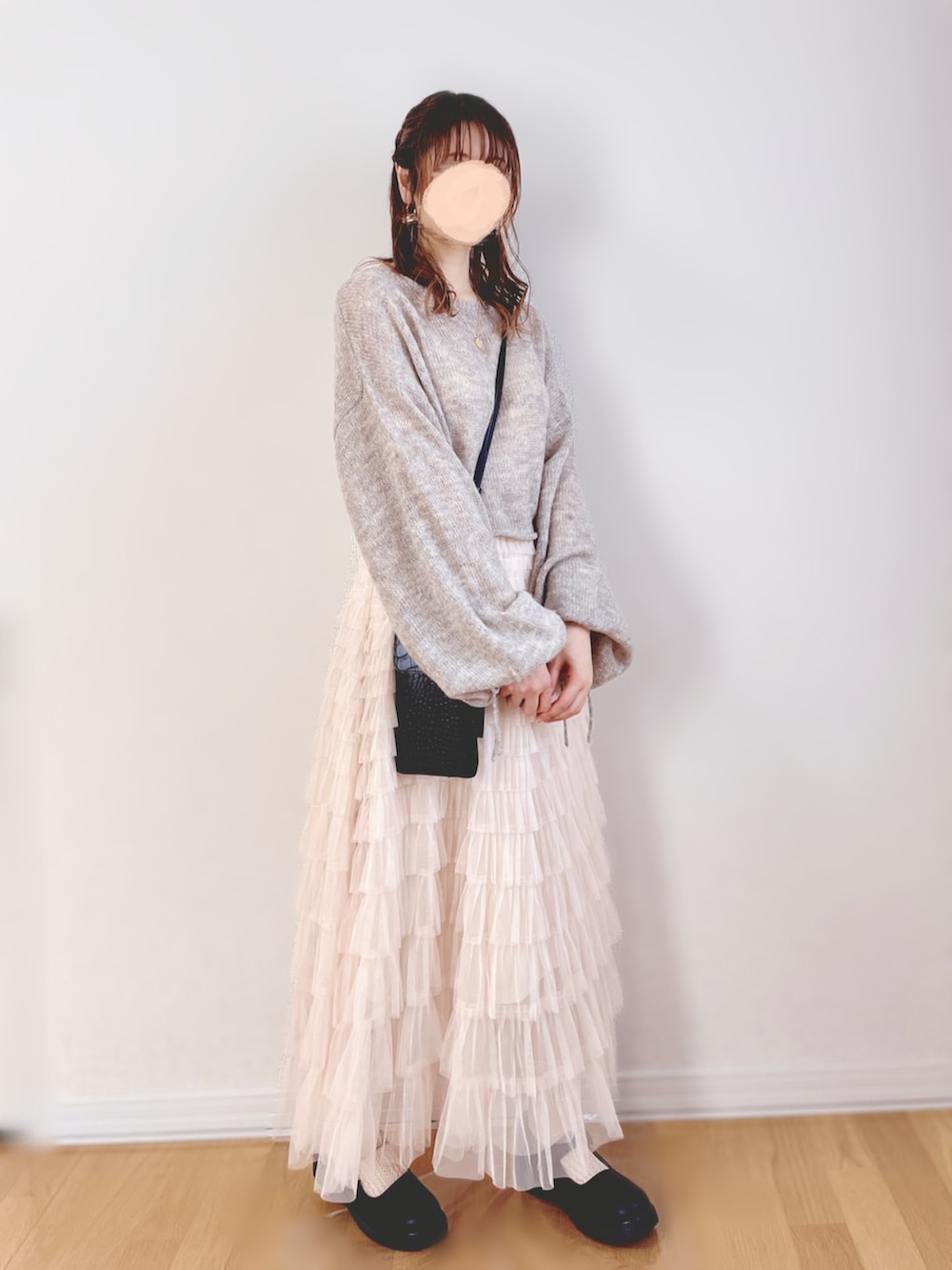 グレー系のニット/セーター、ホワイト系のスカート、ブラック系のショルダーバッグを着用したレディースの秋コーディネートの3枚目の写真