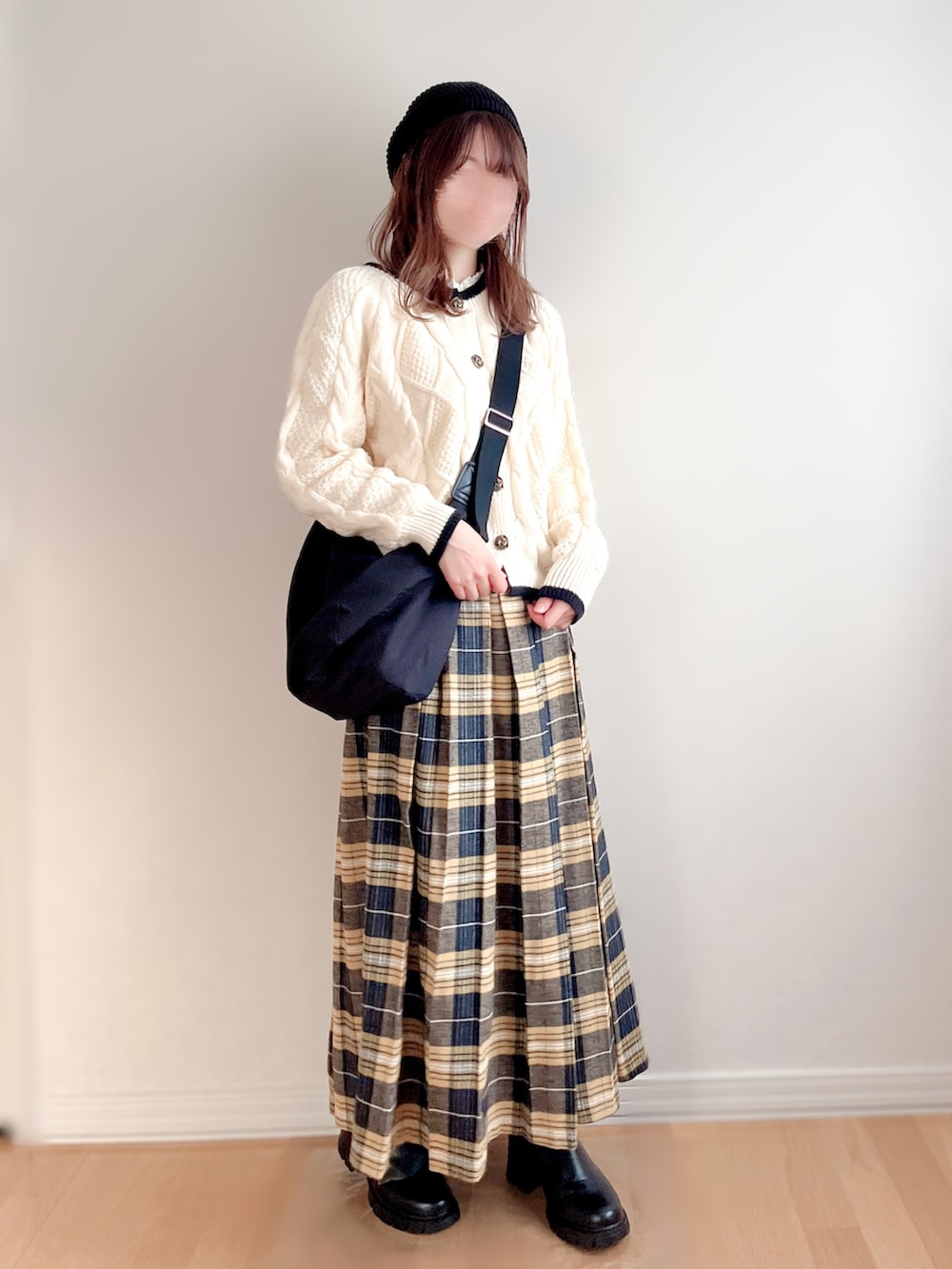 ホワイト系のカーディガン/ボレロ、イエロー系のスカート、ブラック系のブーツを着用したレディースの秋コーディネートの2枚目の写真
