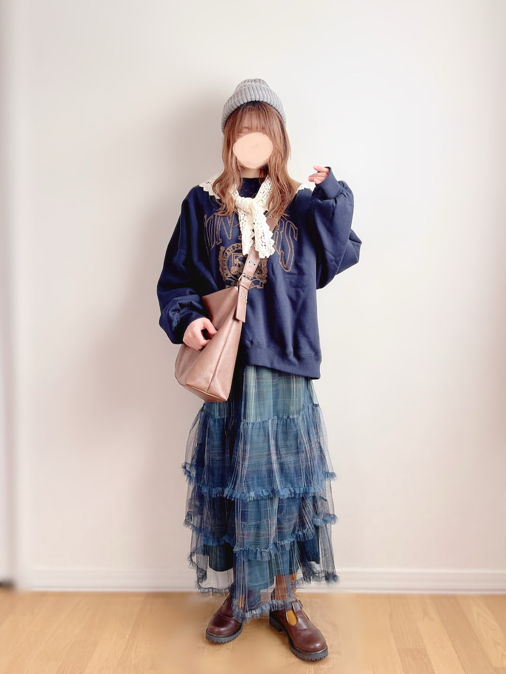 ブルー系のスウェット、グリーン系のスカート、ブラウン系のショルダーバッグを着用したレディースの冬コーディネートの2枚目の写真