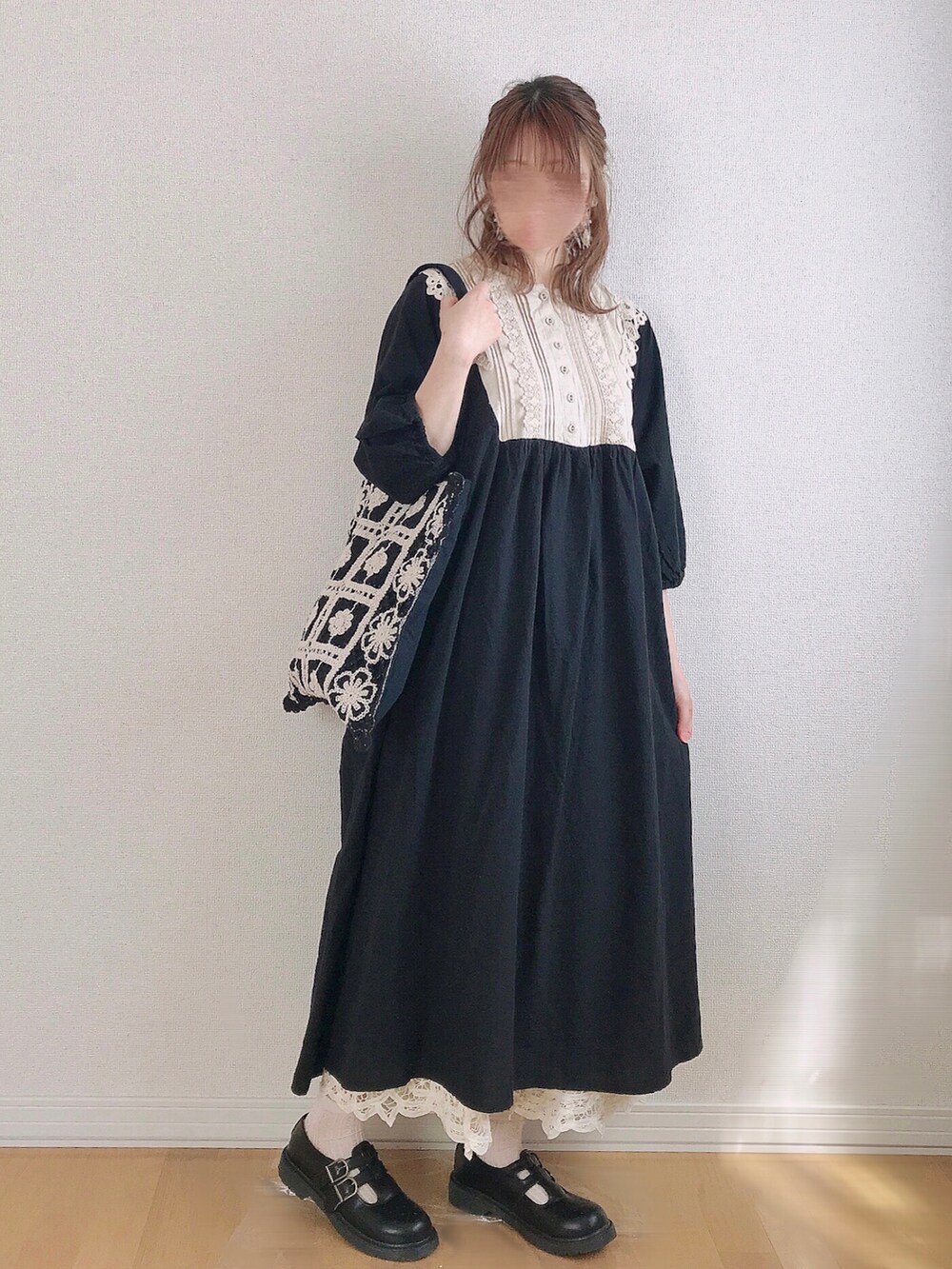 ブラック系のトートバッグ、ブラック系のドレスシューズ、ベージュ系のピアス(両耳用)を着用したレディースの春コーディネートの3枚目の写真