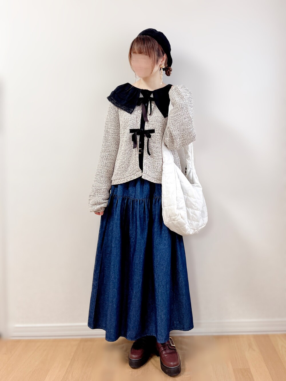 ブルー系のスカート、ベージュ系のショルダーバッグ、ブラウン系のローファーを着用したレディースの秋コーディネートの4枚目の写真