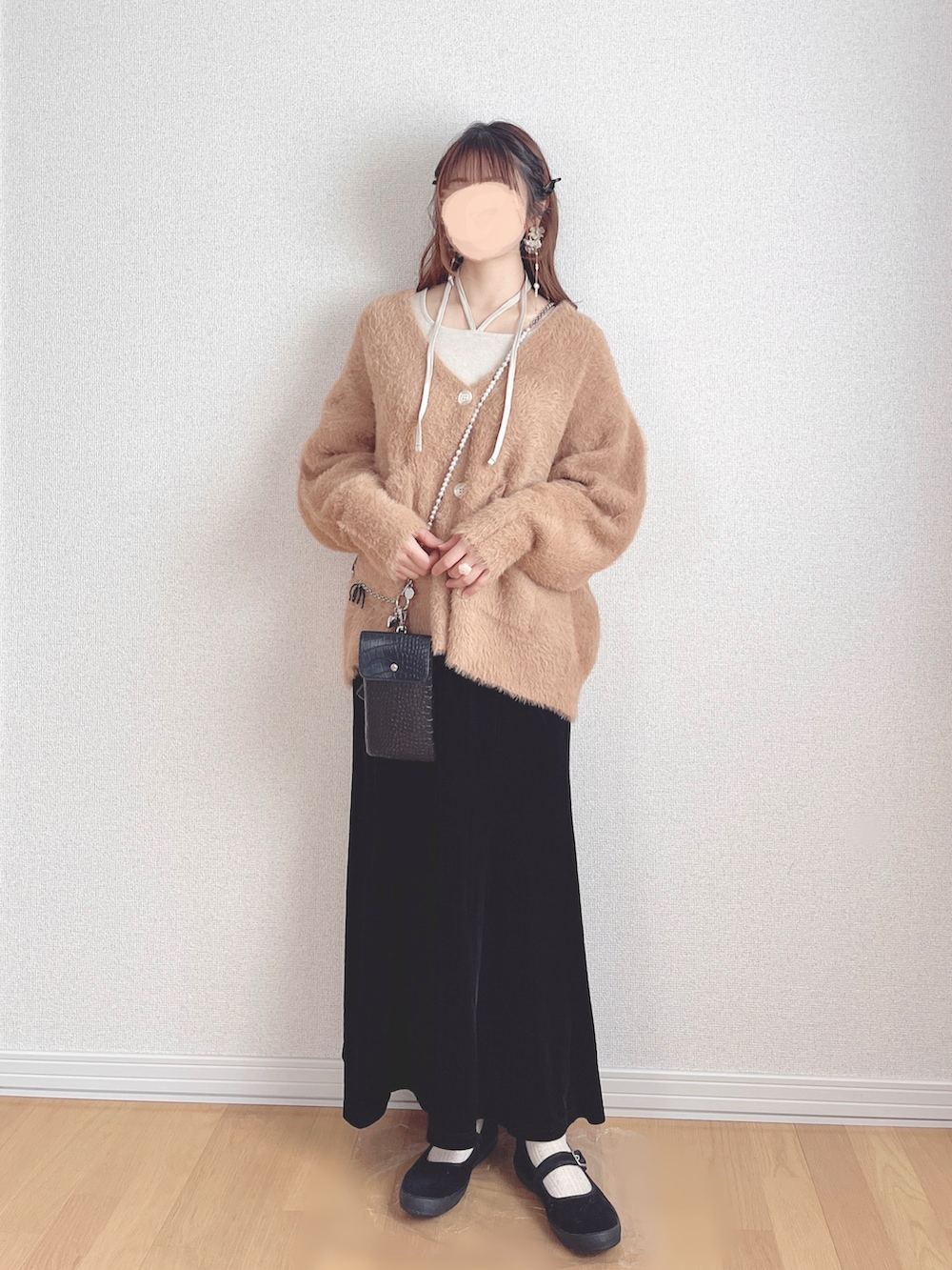 ベージュ系のTシャツ/カットソー、オレンジ系のカーディガン/ボレロ、ブラック系のスカートを着用したレディースの冬コーディネートの3枚目の写真