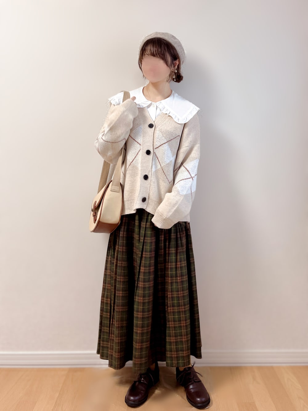 ベージュ系のカーディガン/ボレロ、ホワイト系のシャツ/ブラウス、ブラウン系のスカートを着用したレディースの秋コーディネートの2枚目の写真