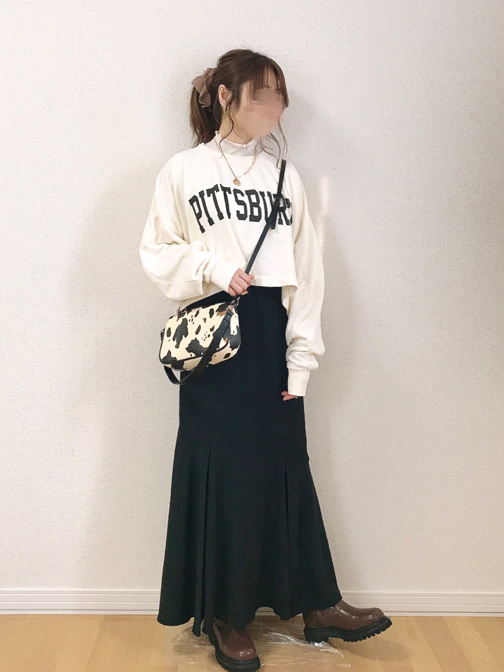 ホワイト系のスウェット、ブラック系のスカート、ホワイト系のブルゾンを着用したレディースの冬コーディネートの3枚目の写真