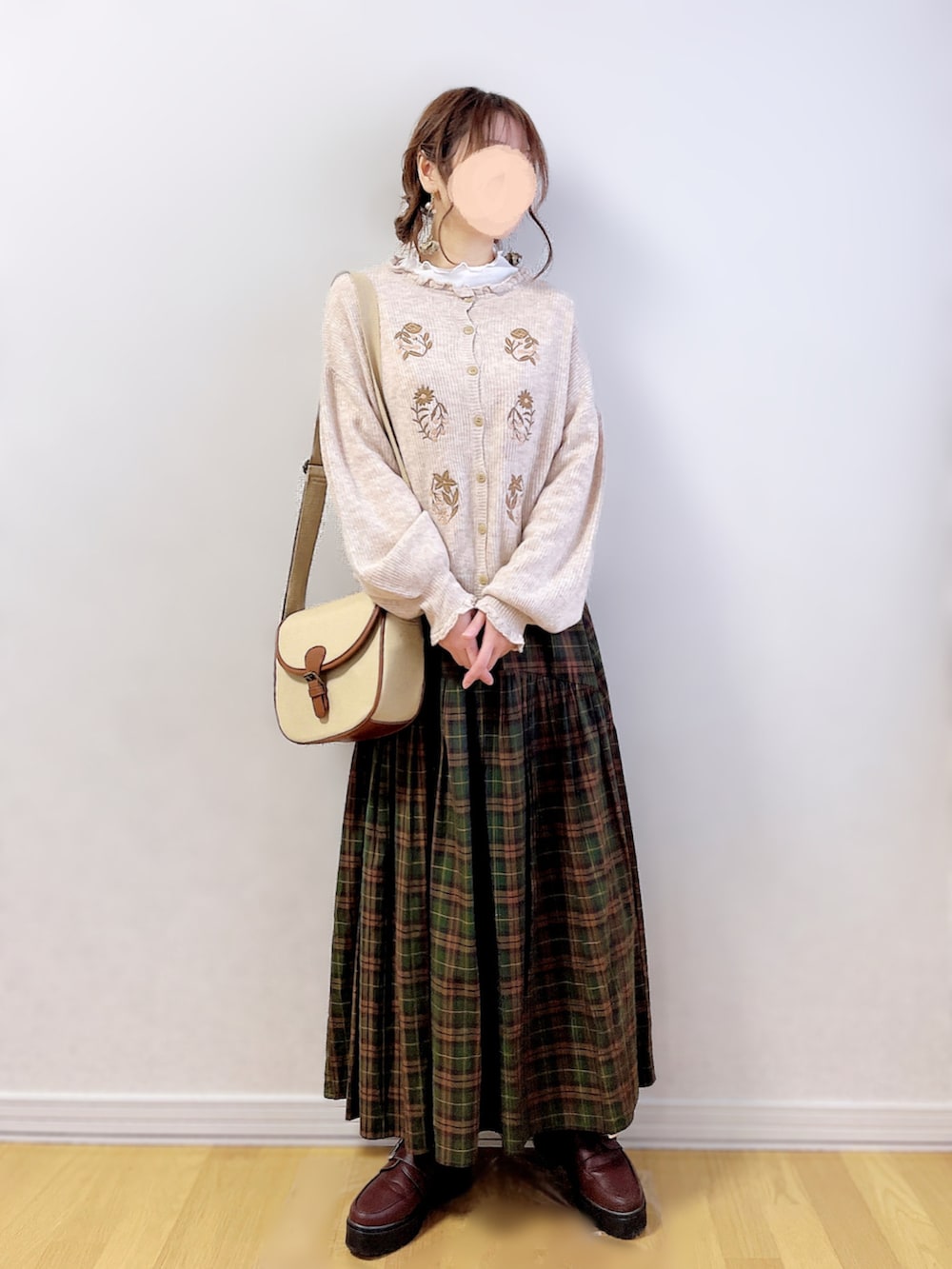 ホワイト系のTシャツ/カットソー、ブラウン系のスカート、ベージュ系のショルダーバッグを着用したレディースの冬コーディネートの4枚目の写真