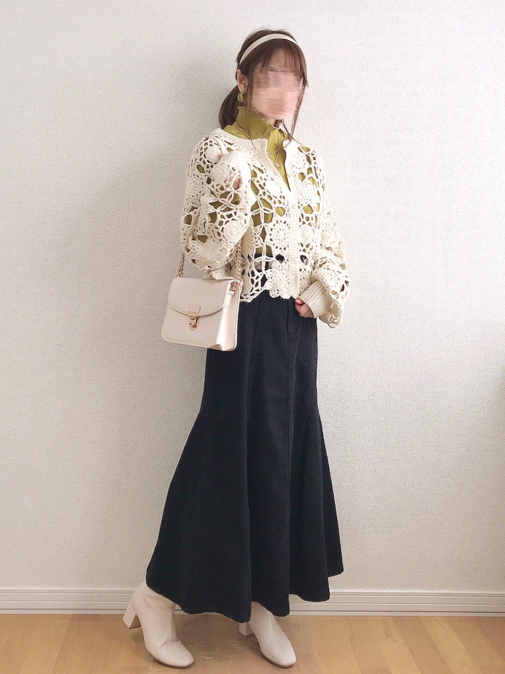 ホワイト系のカーディガン/ボレロ、イエロー系のTシャツ/カットソー、ブラック系のデニムスカートを着用したレディースの冬コーディネートの3枚目の写真