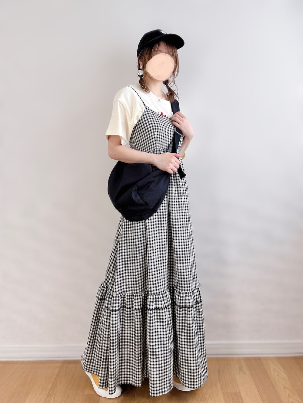 ブラック系のワンピース、ホワイト系のTシャツ/カットソー、ブラック系のショルダーバッグを着用したレディースの夏コーディネートの3枚目の写真