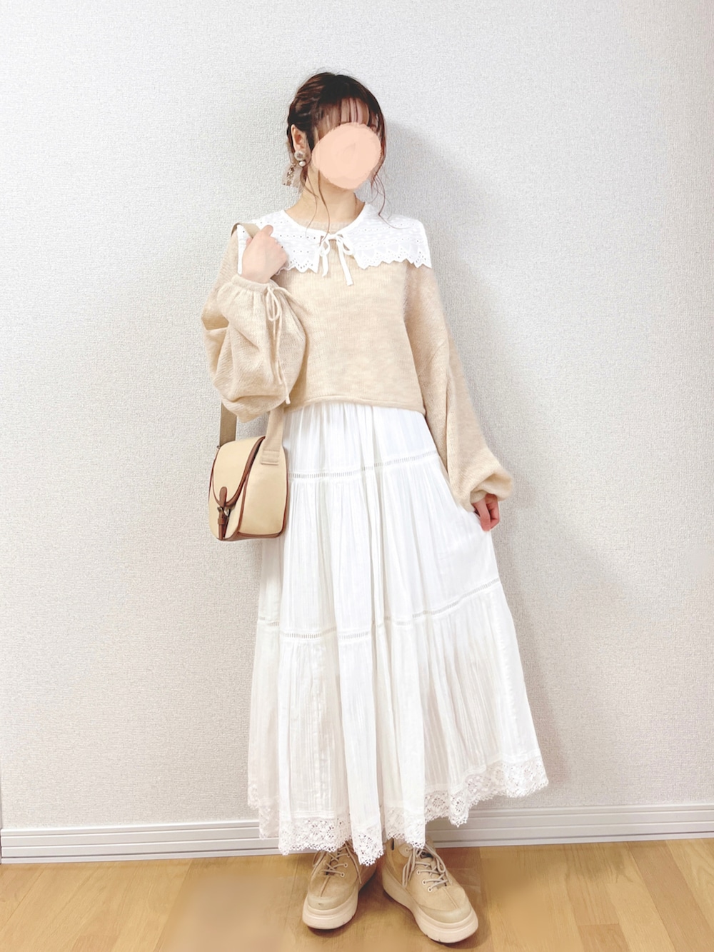 ベージュ系のニット/セーター、ホワイト系のスカート、ベージュ系のショルダーバッグを着用したレディースの秋コーディネートの3枚目の写真