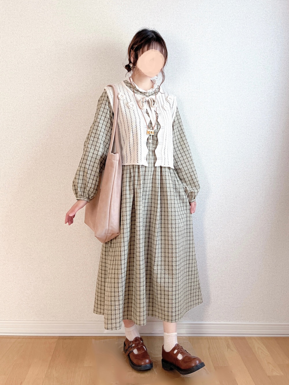 グリーン系のワンピース、ホワイト系のベスト、ベージュ系のトートバッグを着用したレディースの秋コーディネートの2枚目の写真