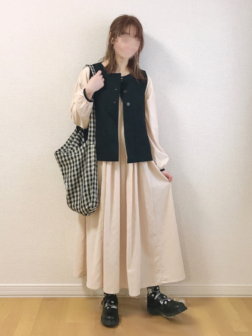 ホワイト系のワンピース、ブラック系のベスト、ブラック系のその他シューズを着用したレディースの春コーディネートの2枚目の写真