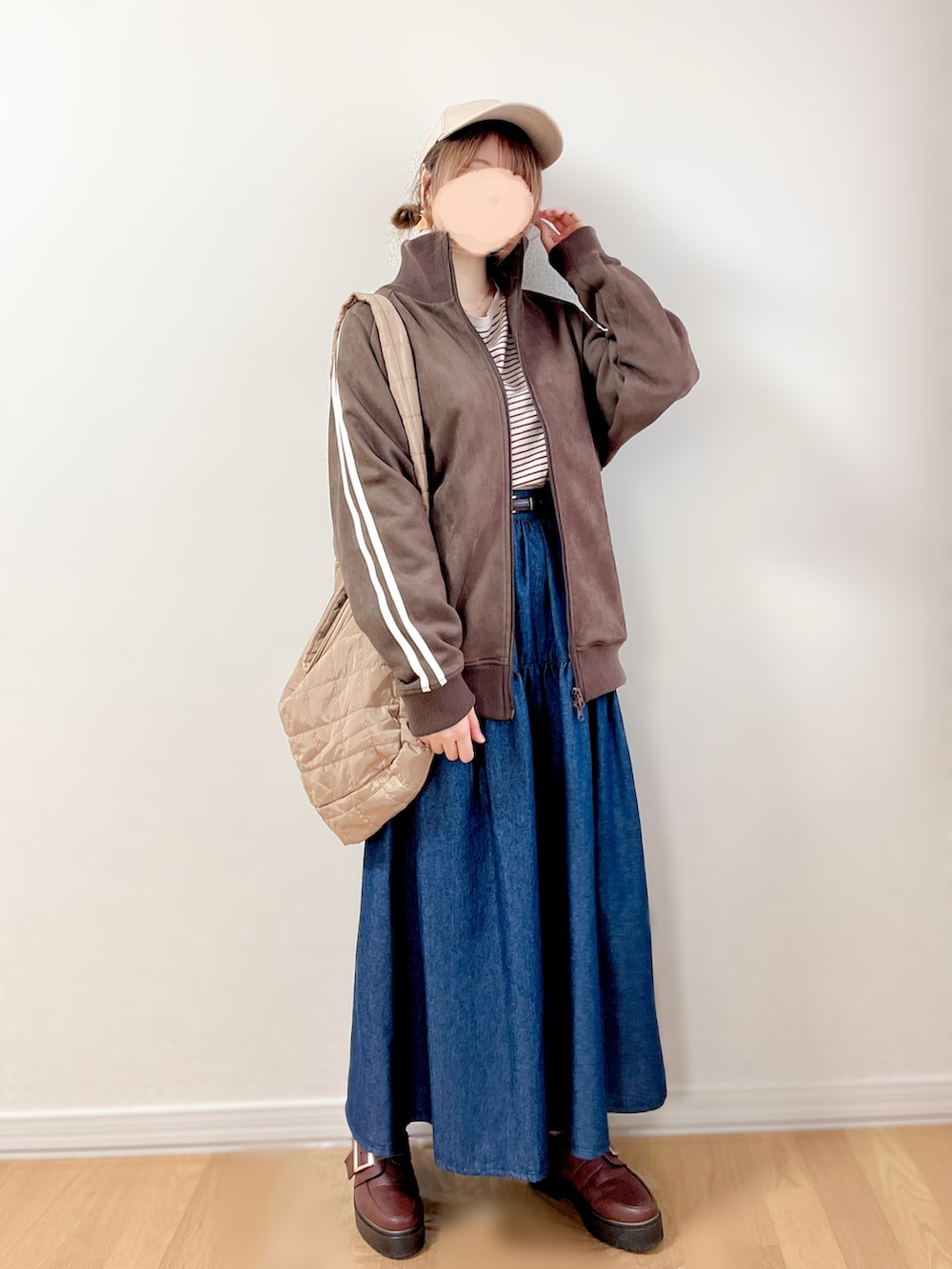 ブラウン系のジャージ、ブルー系のスカート、ベージュ系のショルダーバッグを着用したレディースの秋コーディネートの4枚目の写真