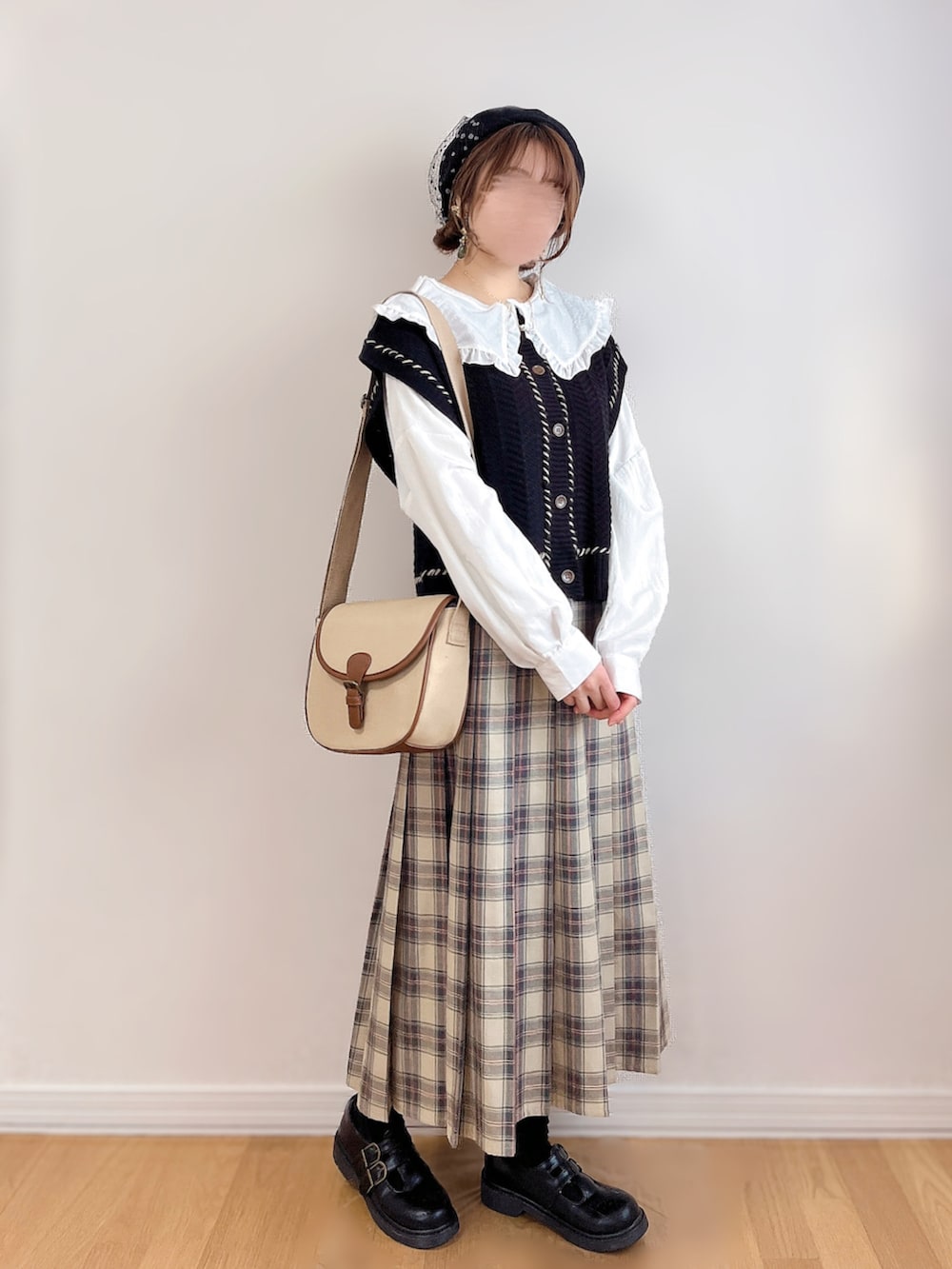 ホワイト系のシャツ/ブラウス、ブラック系のベスト、ベージュ系のスカートを着用したレディースの冬コーディネートの3枚目の写真