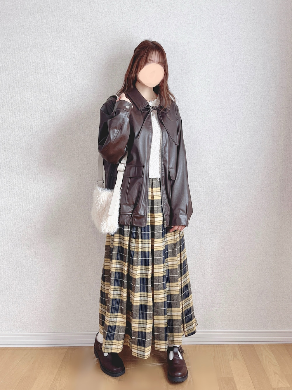 ブラウン系のブルゾン、ホワイト系のベスト、ホワイト系のTシャツ/カットソーを着用したレディースの冬コーディネートの2枚目の写真