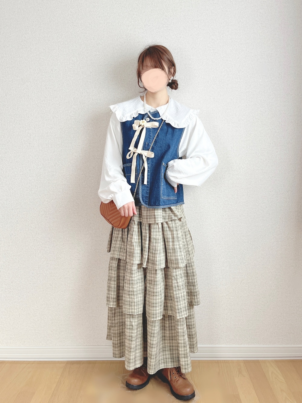 ブルー系のベスト、ホワイト系のシャツ/ブラウス、グリーン系のスカートを着用したレディースの夏コーディネートの2枚目の写真