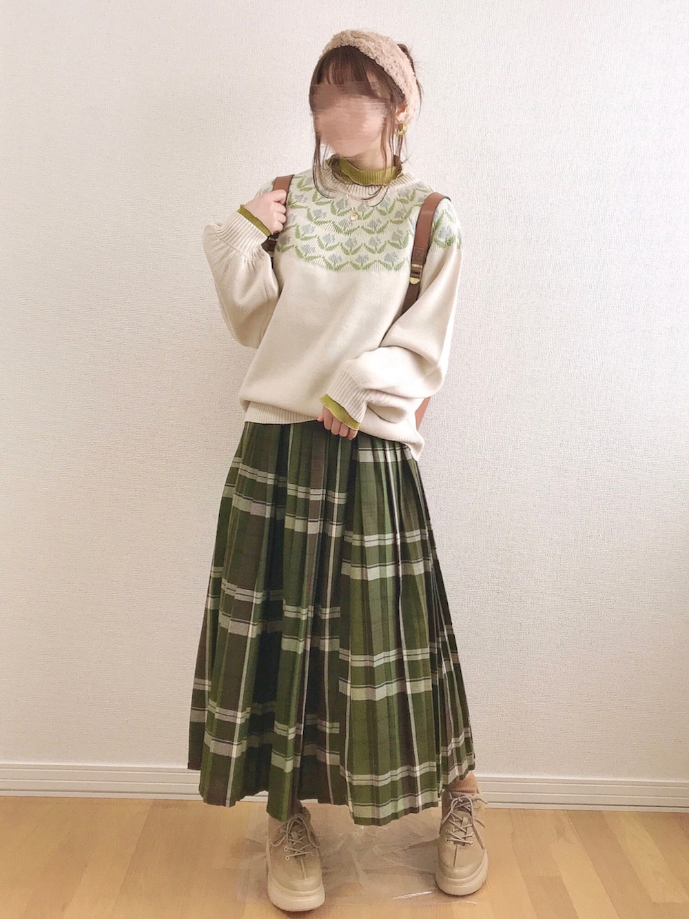 イエロー系のTシャツ/カットソー、イエロー系のバックパック/リュック、ベージュ系のスニーカーを着用したレディースの冬コーディネートの3枚目の写真