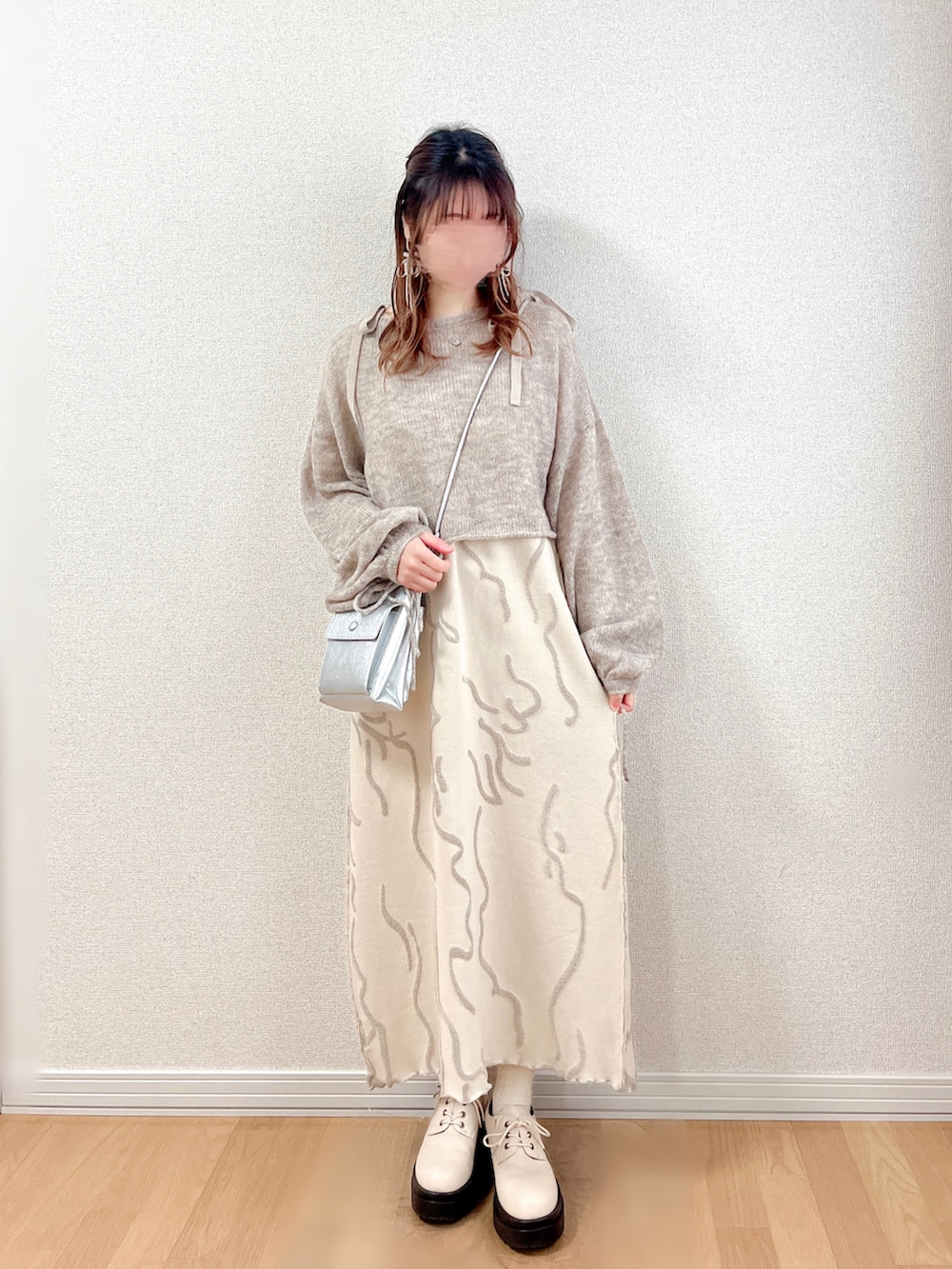 ベージュ系のワンピース、グレー系のニット/セーター、シルバー系のショルダーバッグを着用したレディースの冬コーディネートの3枚目の写真