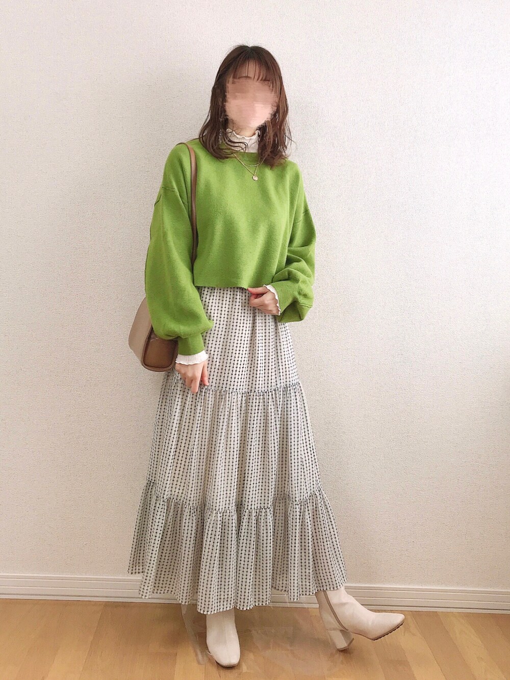 グリーン系のニット/セーター、ホワイト系のTシャツ/カットソー、ホワイト系のスカートを着用したレディースの冬コーディネートの3枚目の写真