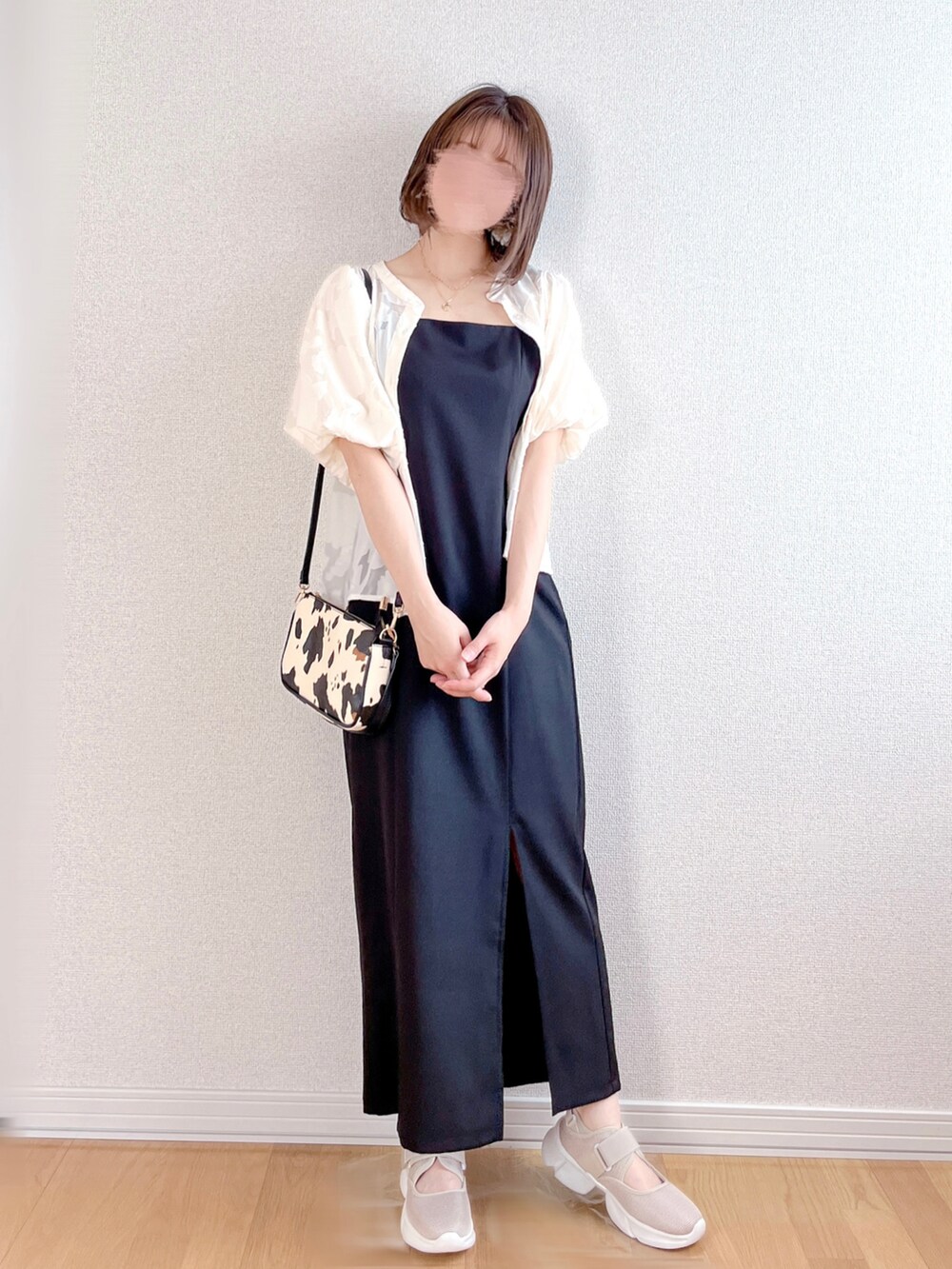 ブラック系のワンピース、ベージュ系のスニーカー、ホワイト系のショルダーバッグを着用したレディースの夏コーディネートの3枚目の写真