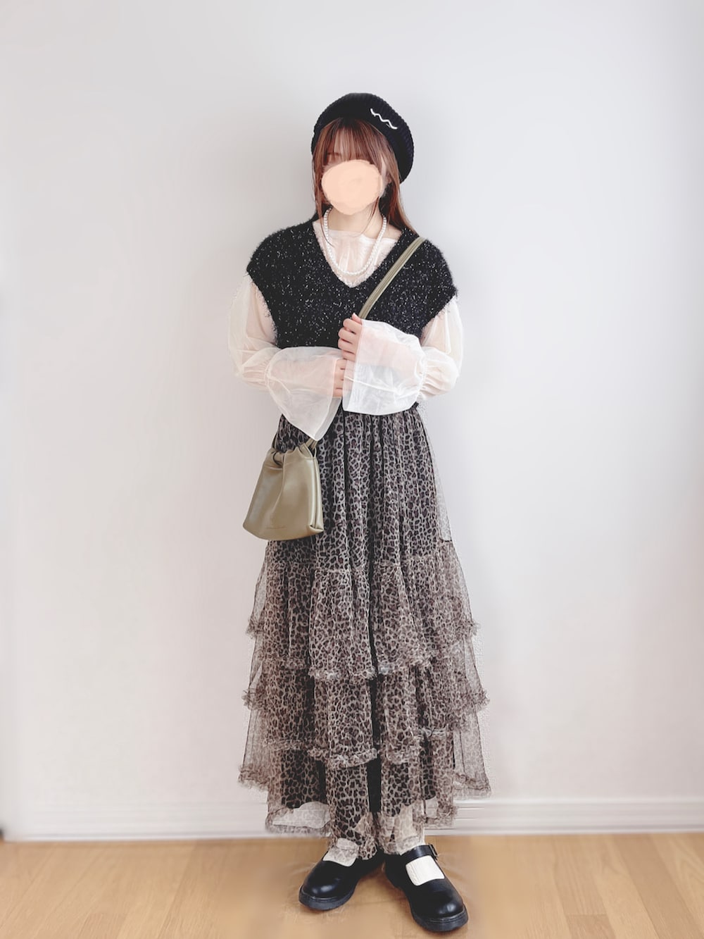 ブラック系のベスト、ホワイト系のTシャツ/カットソー、ベージュ系のスカートを着用したレディースの秋コーディネートの4枚目の写真