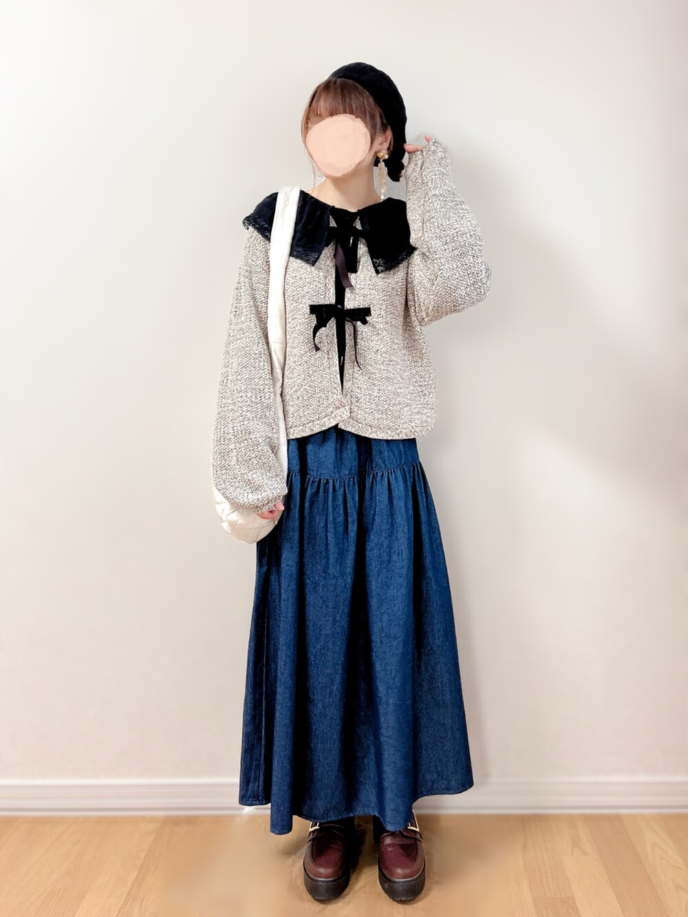 ブルー系のスカート、ベージュ系のショルダーバッグ、ブラウン系のローファーを着用したレディースの秋コーディネートの2枚目の写真