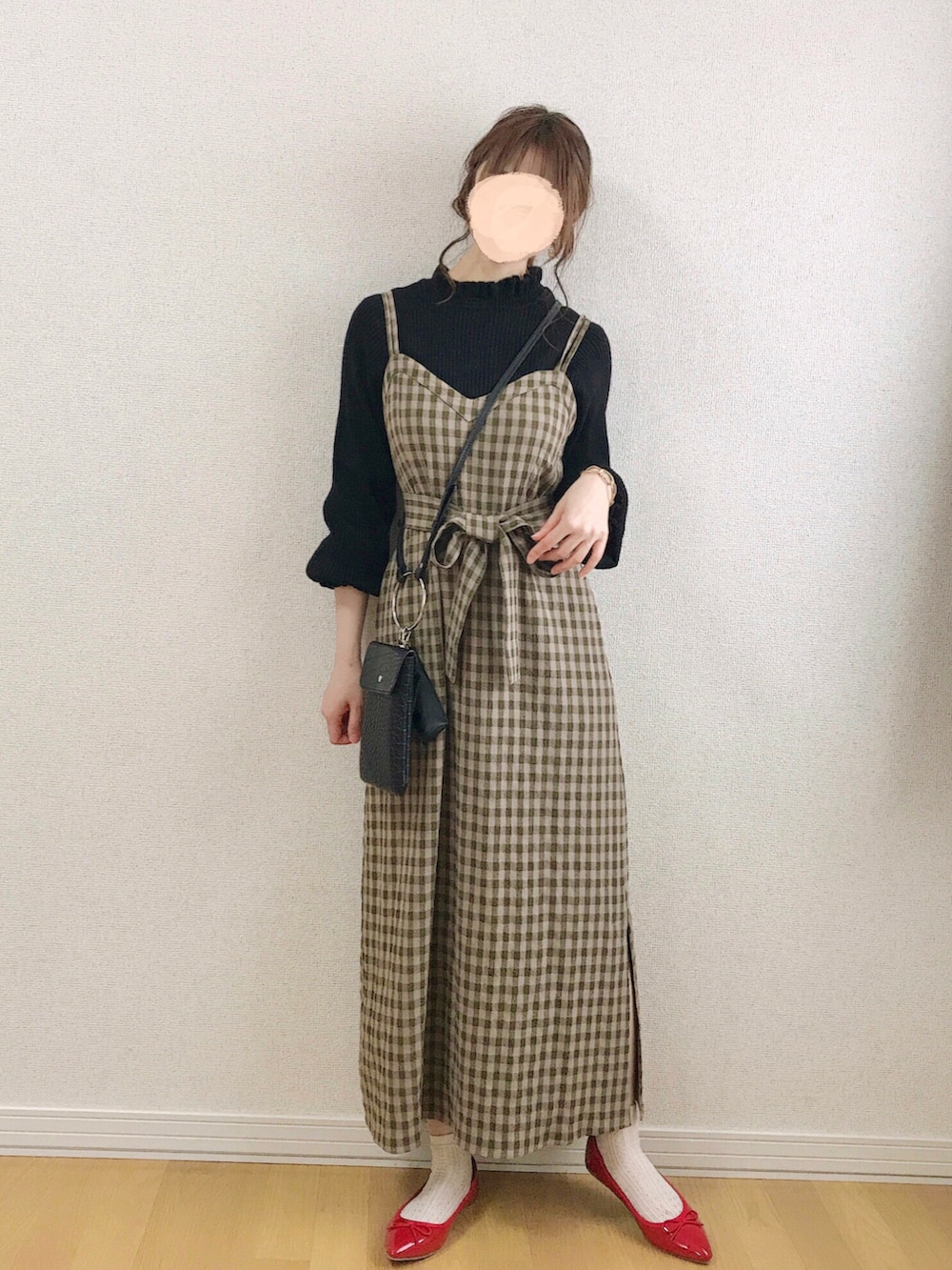 グリーン系のワンピース、ブラウン系のニット/セーター、ブラック系のショルダーバッグを着用したレディースの春コーディネートの3枚目の写真