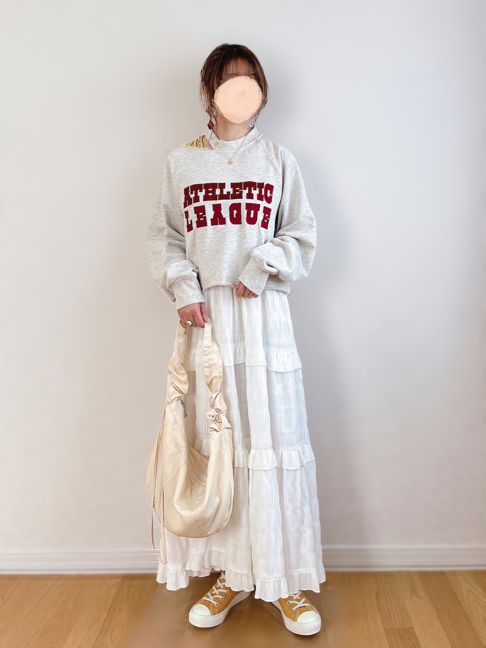 グレー系のスウェット、ホワイト系のワンピース、ゴールド系のスニーカーを着用したレディースの春コーディネートの4枚目の写真