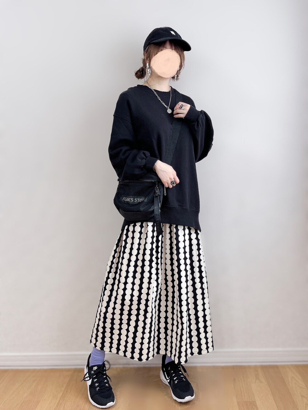 ブルー系のスウェット、ブラック系のスカート、ブラック系のスニーカーを着用したレディースの春コーディネートの3枚目の写真