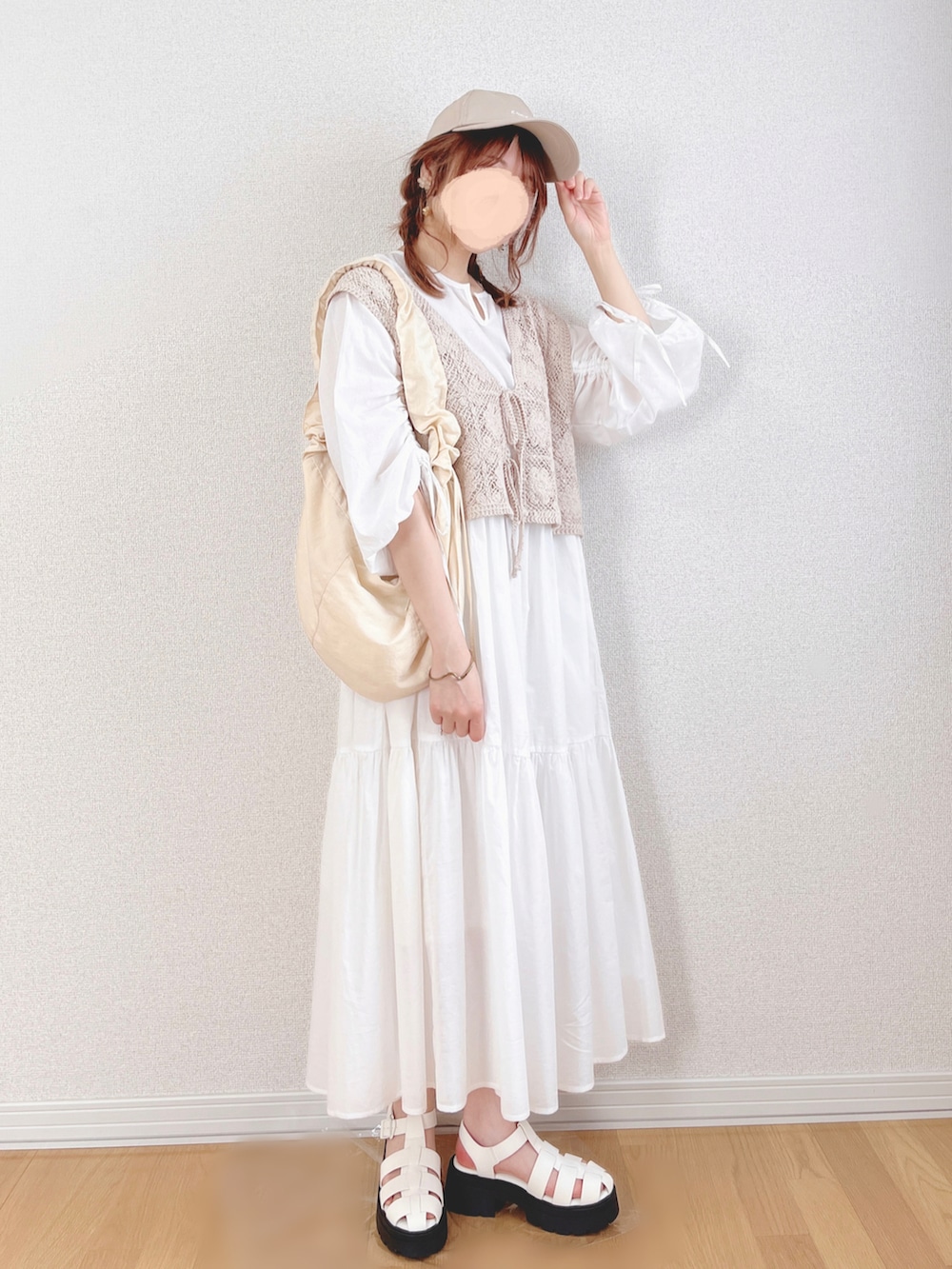 ホワイト系のワンピース、ベージュ系のベスト、ホワイト系のショルダーバッグを着用したレディースの夏コーディネートの2枚目の写真